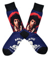 Shown in a flatlay, a pair of Socksmith's blue cotton men's crew socks with black cuff/heel/toe, and Jimi Hendrix portrait