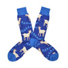 Shown in a flatlay, a pair of Socksmith's blue cotton men's crew socks with light blue heel/cuff/toe, screaming white billy goats and “AAAAH!!” text in an all-over pattern