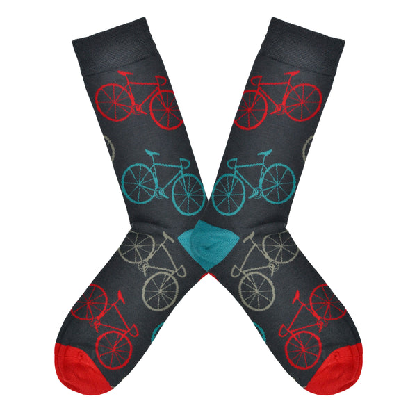Shown in a flatlay, a pair of Socksmith's bamboo men's crew socks in gray with simple bicycles on them