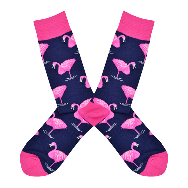 Shown in a flatlay, a pair of Socksmith's navy cotton men's crew socks with pink flamingo all over pattern