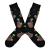 Shown in a flatlay, a pair of Socksmith's black cotton men's crew socks with chill sloths hanging from vibes