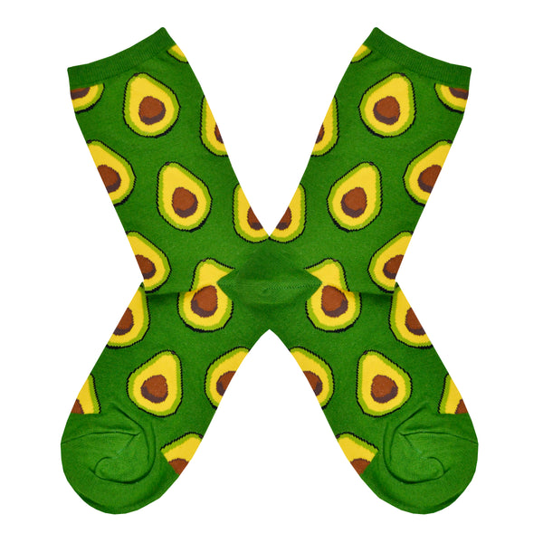 These green cotton women's novelty crew socks by the brand Socksmith feature light green avocados sliced in half showing their brown pits.