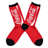 Shown in a flat lay, a pair of Sock Smith brand women's cotton crew sock in red with a black heel, toe, and cuff. The leg of the sock features the iconic Coca Cola branding in white lettering.