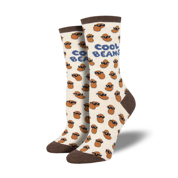 Shown on leg forms, a pair of Sock Smith brand women's cotton crew socks in ivory with a brown heel, toe, and cuff. The sock features an all over motif of little brown beans in black sunglasses, the leg of the sock reads, "Cool Beans" in a blue font.