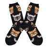 Shown in a flatlay, a pair of black socks with different types of cat faces wearing black rimmed "hipster" glasses all over the sock.