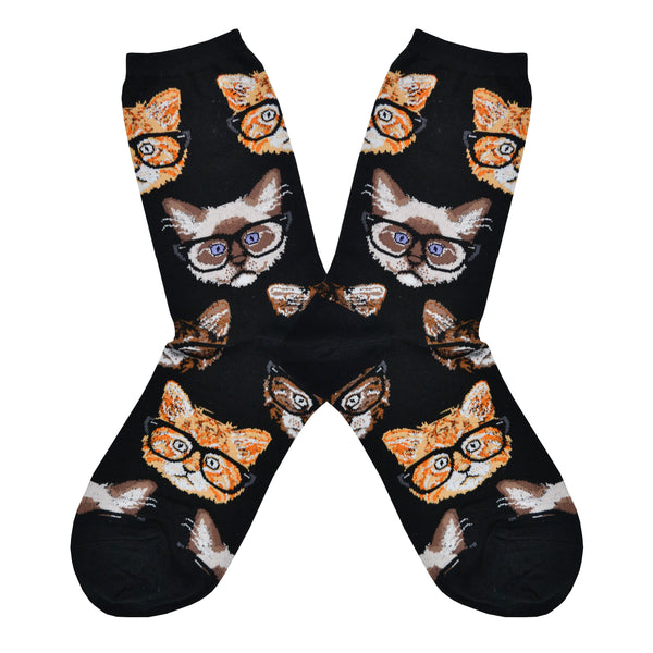 Shown in a flatlay, a pair of black socks with different types of cat faces wearing black rimmed "hipster" glasses all over the sock.