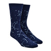 Shown on a foot form, a pair of Sock It To Me navy blue cotton men's crew socks with glow in the dark constellation all over pattern