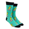 Shown on a foot form, a pair of Sock It To turquoise cotton men's crew socks with black cuff/heel/toe and goofy bananas skateboarding while wearing cool sunglasses