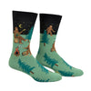 Shown on a foot form from a different angle, a pair of Sock It To Me green cotton men's crew socks with black starry sky and various sasquatches enjoying a campfire (playing banjo, roasting marshmallows) among a pine forest