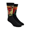 Shown on foot forms side by side, a pair Sock It to Me cotton men's crew socks in black with a yellow, orange, and red background on the leg featuring a green alien and 2 space ships. The text on the sock reads, "They're Here!".