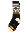 a .png of a pair of black socks with ivory toe and heel, orange stripe details and ivory text that says "sounds like bullshit to me"