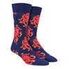 Shown on a leg form, these colorful navy cotton men's crew socks by the brand Socksmith feature bright orange Octopus in a repeated pattern on the foot and leg.