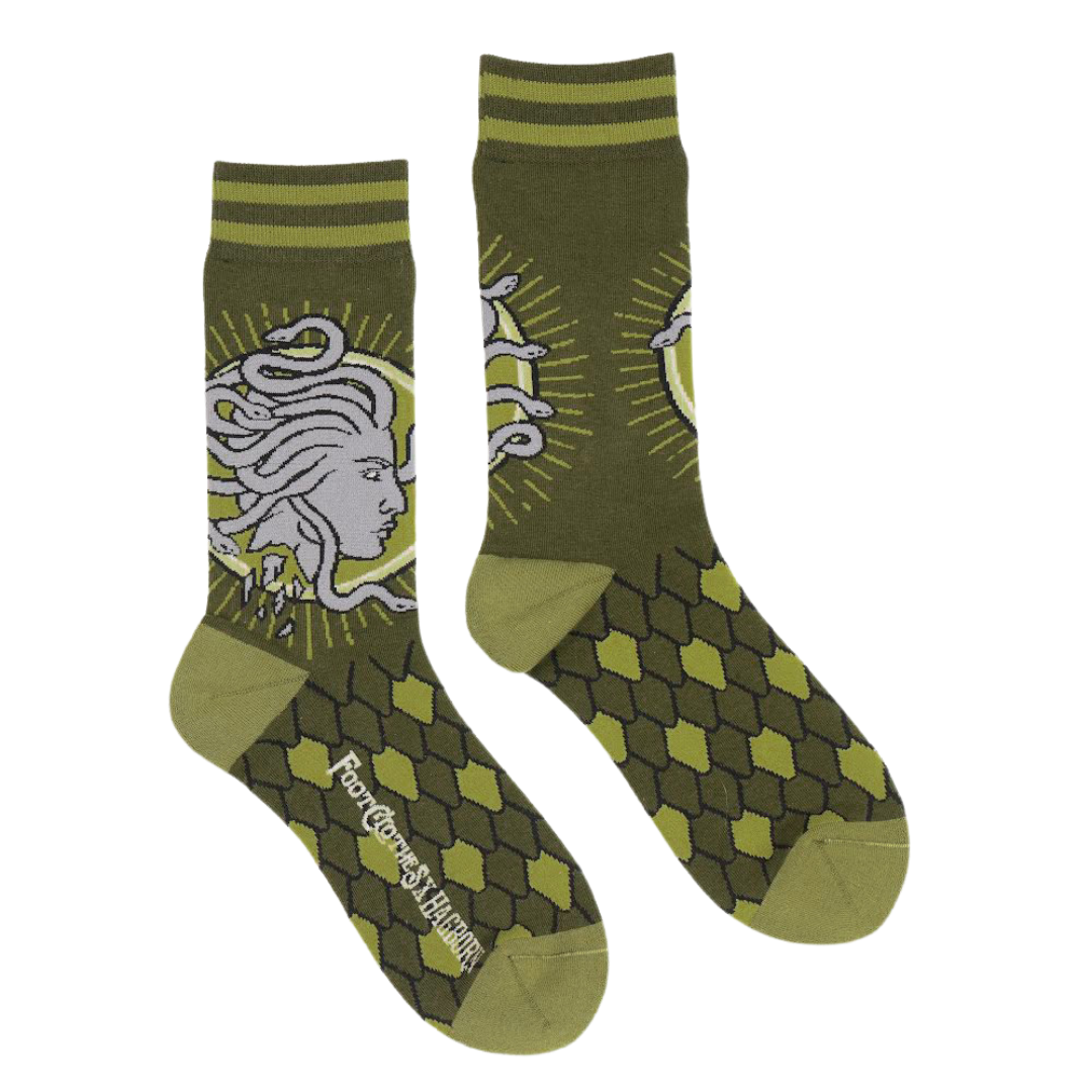 Shown in a flatlay, a pair of unisex dark green socks with a light green heel and toe. The Cuff is striped and the leg of the crew sock has a depiction of Medusa. The foot features a green scale pattern.  