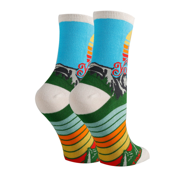 Shown from the back on leg forms, the unisex small Yosemite sock has a blue leg with a white heel, toe, and, cuff. the foot is stripped blue, orange, and, yellow.