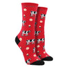 Shown on leg forms, a pair of women's cotton crew socks in red with a black heel and toe. The socks have an all over motif of black and white cows and daisy's. 