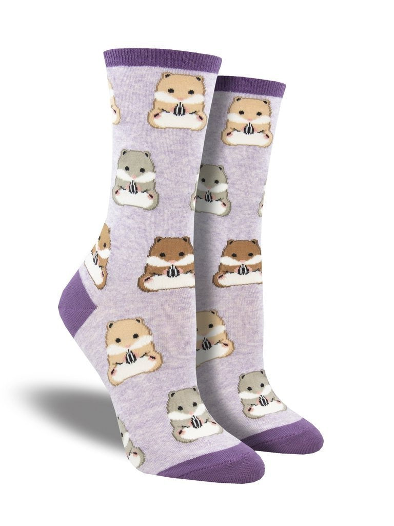Shown on foot forms, a pair of women's Socksmith brand cotton and nylon crew sock in lilac with a purple heel, toe, and cuff. These socks feature an all over pattern of grey, blonde, and brown hamsters holding a little sunflower seed.