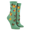 Shown on a leg form, a pair of Socksmith’s light green cotton women’s crew socks with bee print including yellow honeycombs