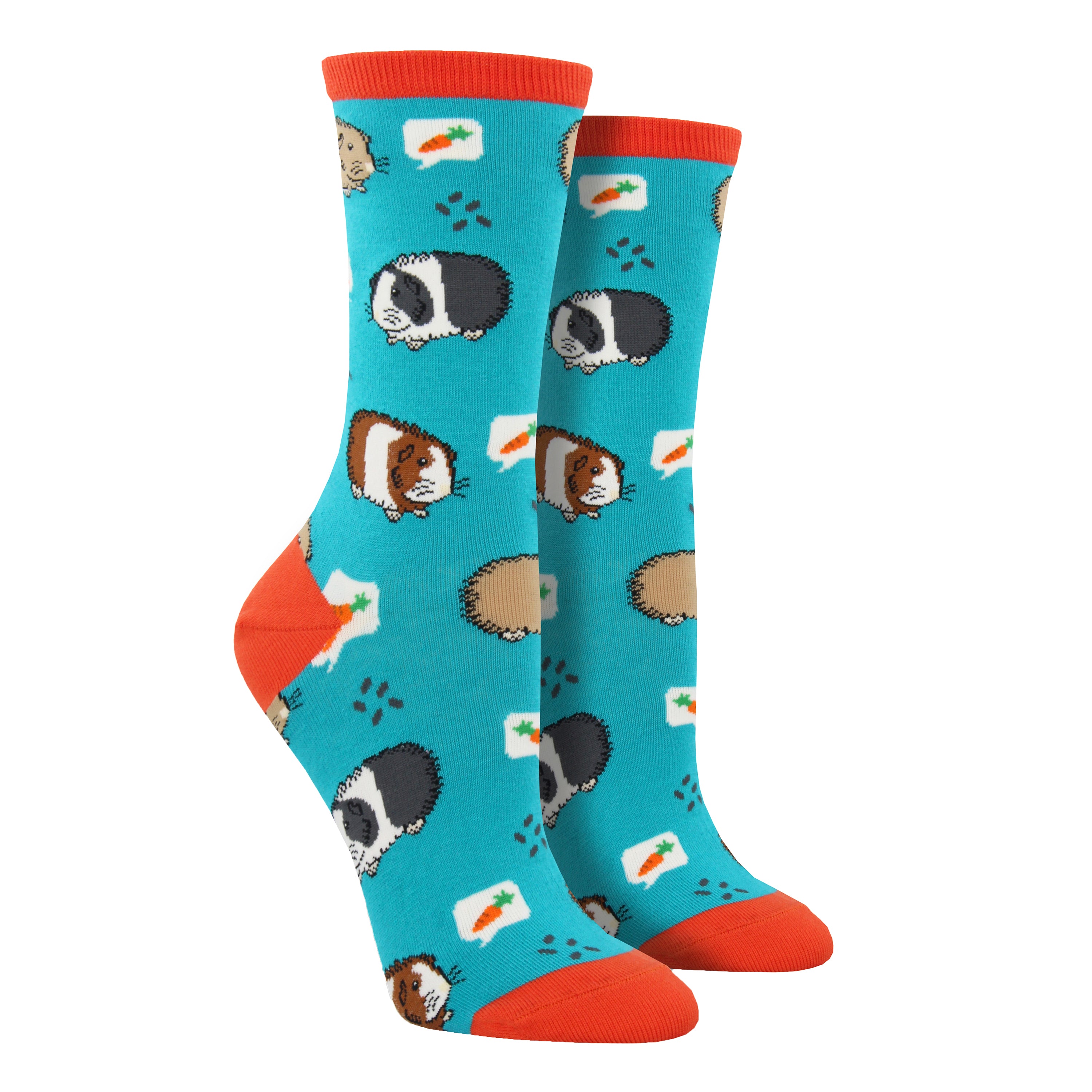 Shown on foot forms, a pair of women's Socksmith brand cotton crew socks in teal with an orange heel, toe, and cuff. The sock has an all over design of guinea pigs thinking about carrots.