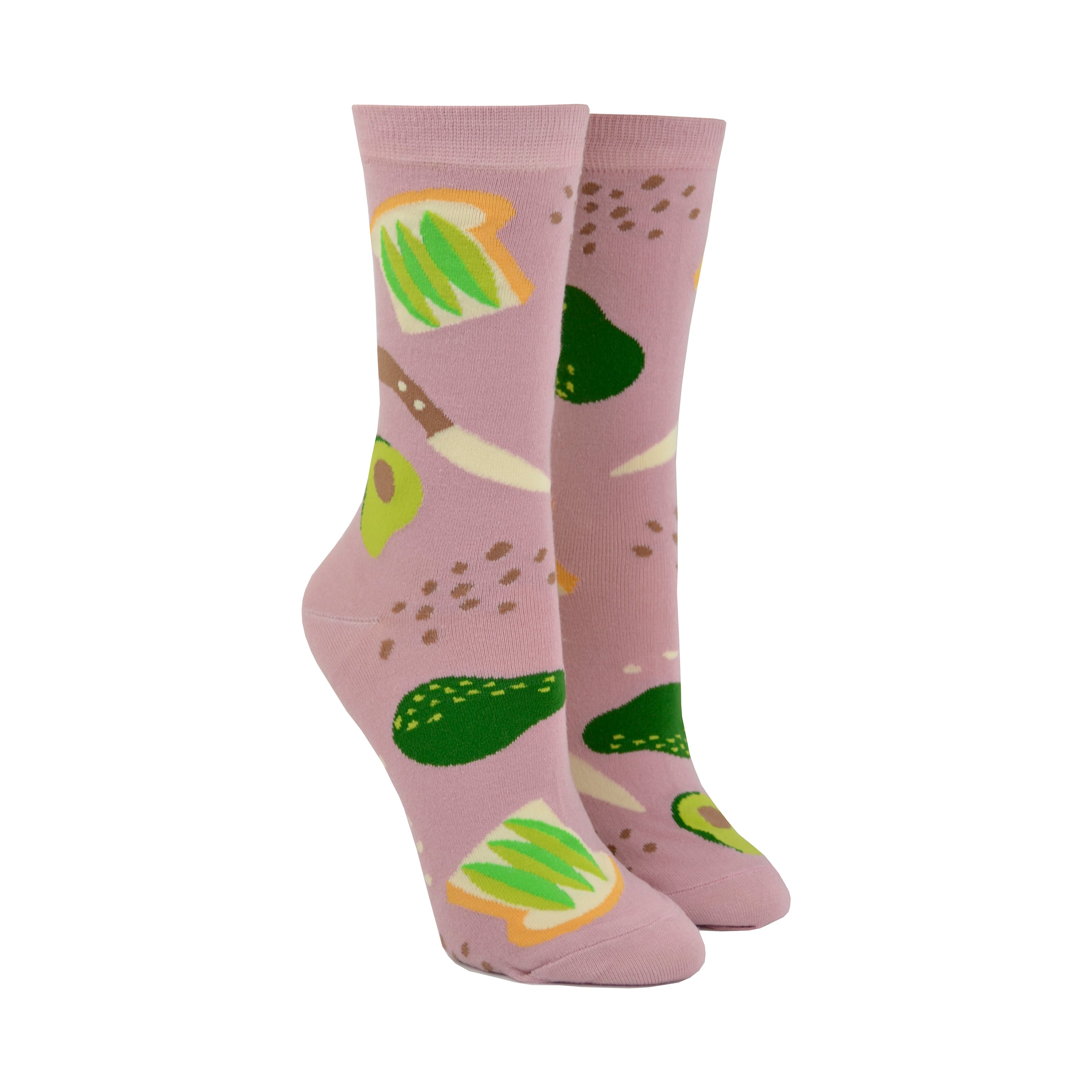 Shown on leg forms, a pair of Yellow Owl Workshop brand women's cotton crew socks in a light brown with an avocado toast theme. Each sock features avocado toast, avocados, salt and pepper, and a knife.