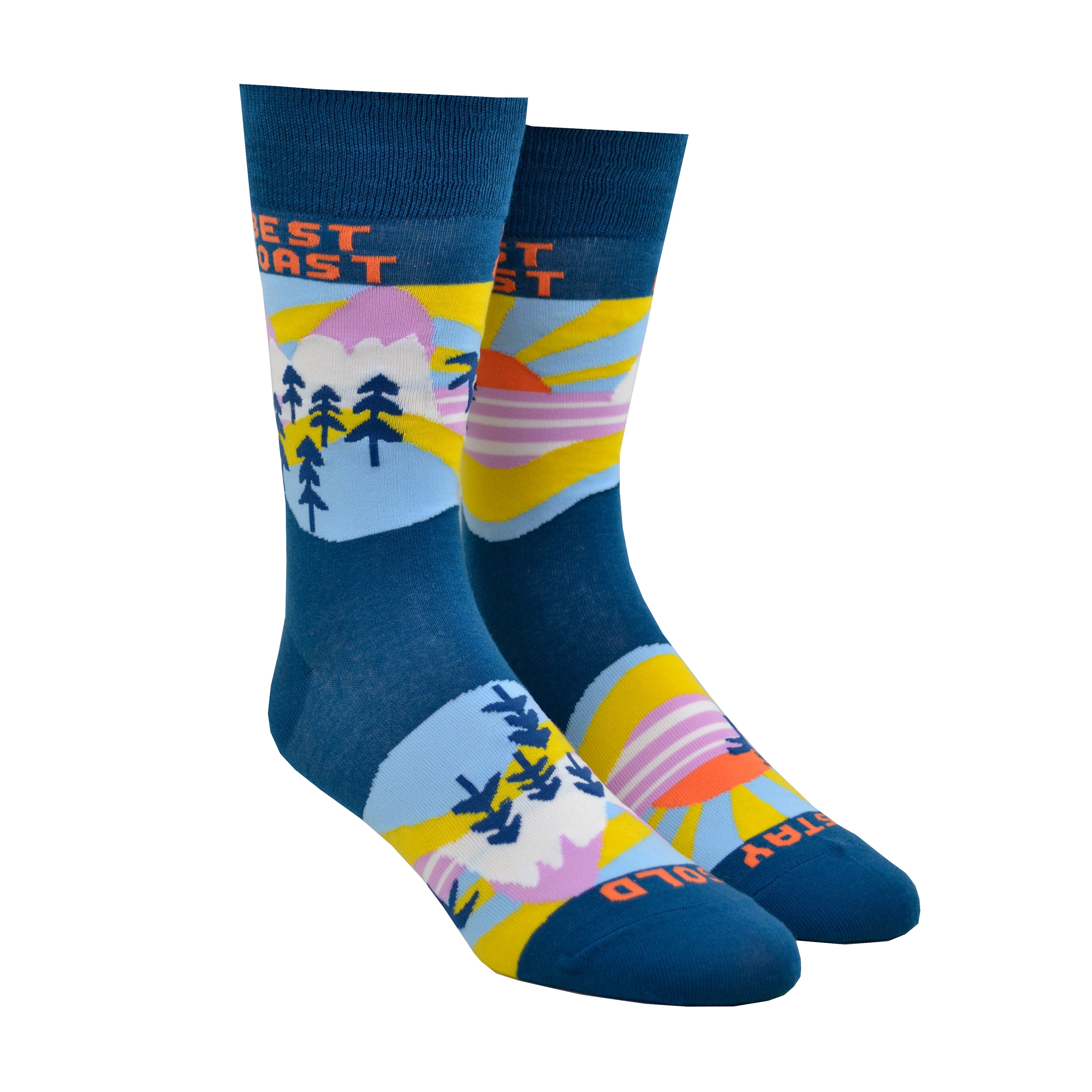 Shown on a leg form, these blue cotton men's novelty crew socks by the brand Yellow Owl Workshop feature an orange and yellow sun setting over a pink landscape with blue palm trees and say the words 