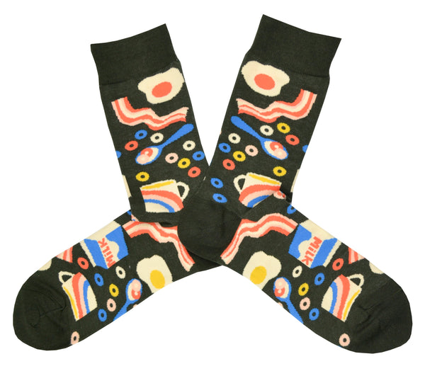 Shown in a flatlay, a pair of Yellow Owl Workshop’s earthy brown nylon-cotton men's crew socks with colorful eggs, bacon, cereal, and milk pattern