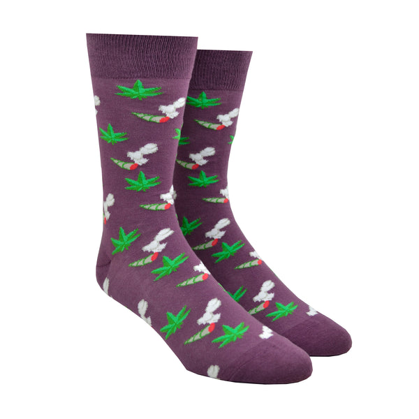 Shown on leg forms, a pair of Yellow Owl Workshop men's nylon and cotton crew socks in purple with an all over design of green marijuana plants and smoking joints.