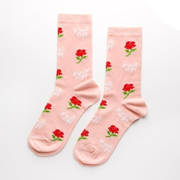 Shown in a flatlay, a pair of women's Yellow Owl Workshop pink cotton crew socks with an all over rose and "Fuck Off" motif in white font.