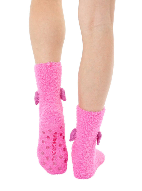 a pair of feet wearing pink fuzzy socks seen from the back to show the non skid grips on the sole and 3D wings on the sides of the ankles