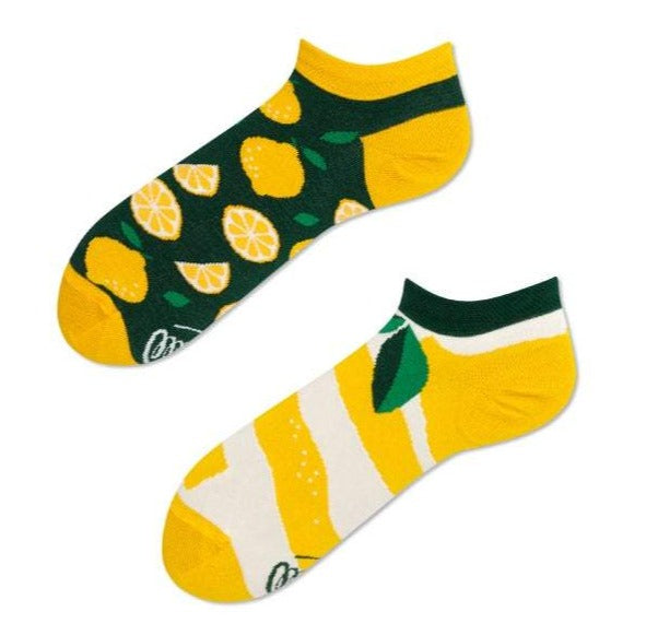 This is a mismatched pair of Many Mornings unisex cotton socks feature whole and cut lemons on one sock and a larger lemon peel design on the other sock.