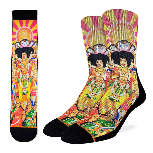 a flat lay of a single sock featuring the cover fro the jimi hendrix album axis: bold as love in shades of yellow, orange and pink next to leg forms wearing the same socks