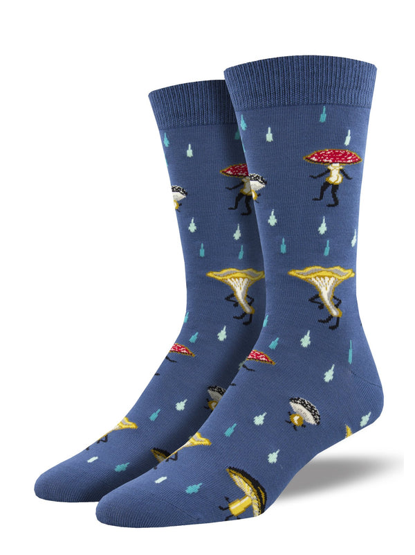Shown on a leg form, a pair of Socksmith's bamboo men's crew socks in blue with adorable cartoon mushroom people that include legs and cheeky butts