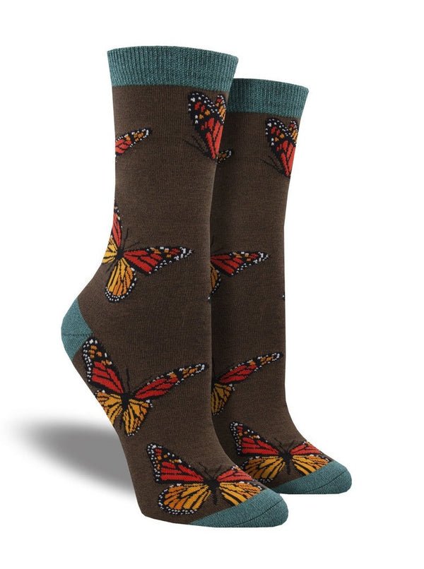 a pair of socks on foot forms depicting monarch butterflies on a dark brown background with teal toe, heel and cuff