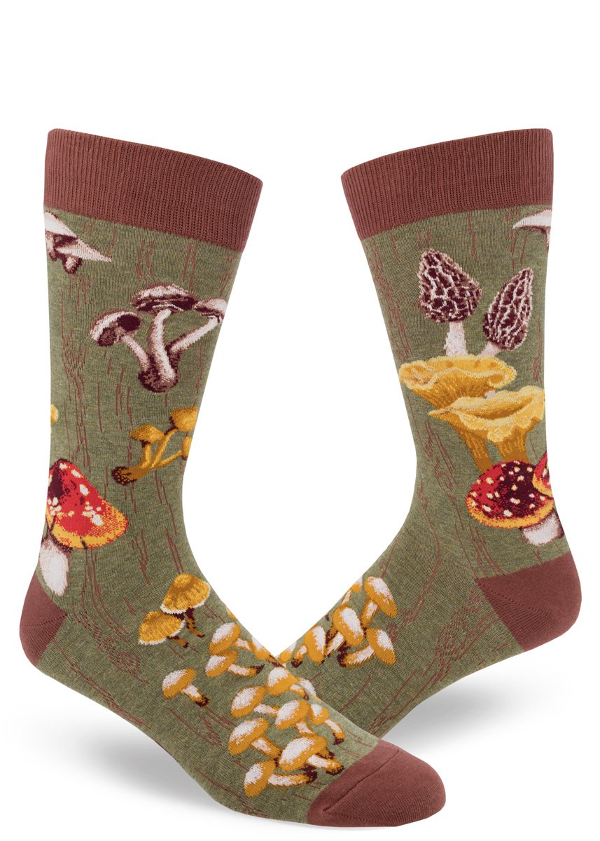 Shown on a foot form in a different angle, a pair of Mod Socks’ green cotton men's crew socks with a large design of different kinds of mushrooms
