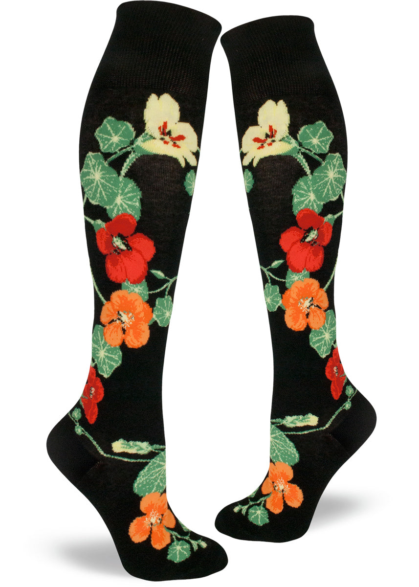 Knee socks with a relaxed cuff featuring the beautiful multicolored nasturtium blossoms and green lush leaves on a black background. 